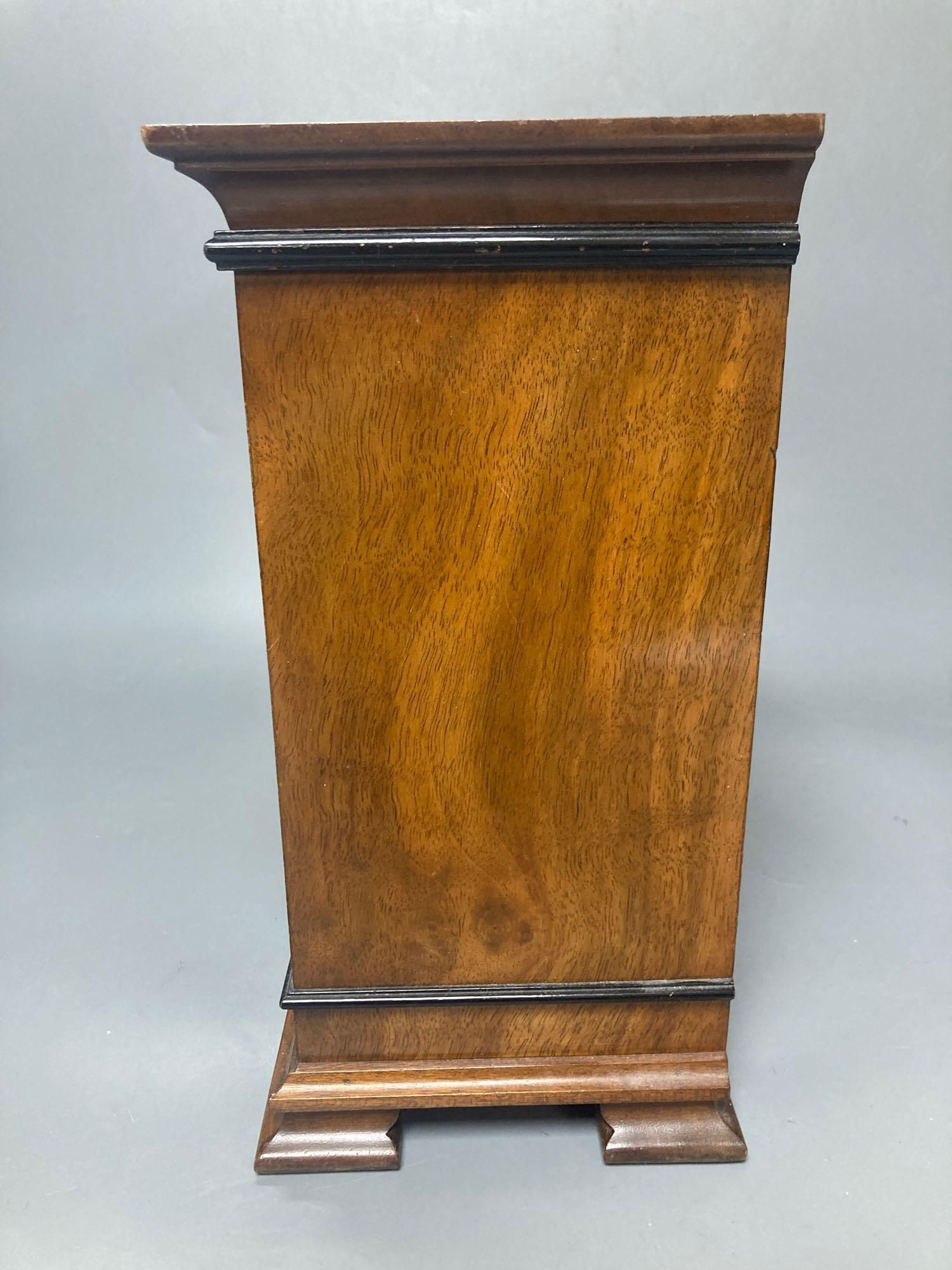 A mahogany mantel clock with ebonised decoration, by Elliott of London, width 33cm, height 25cm